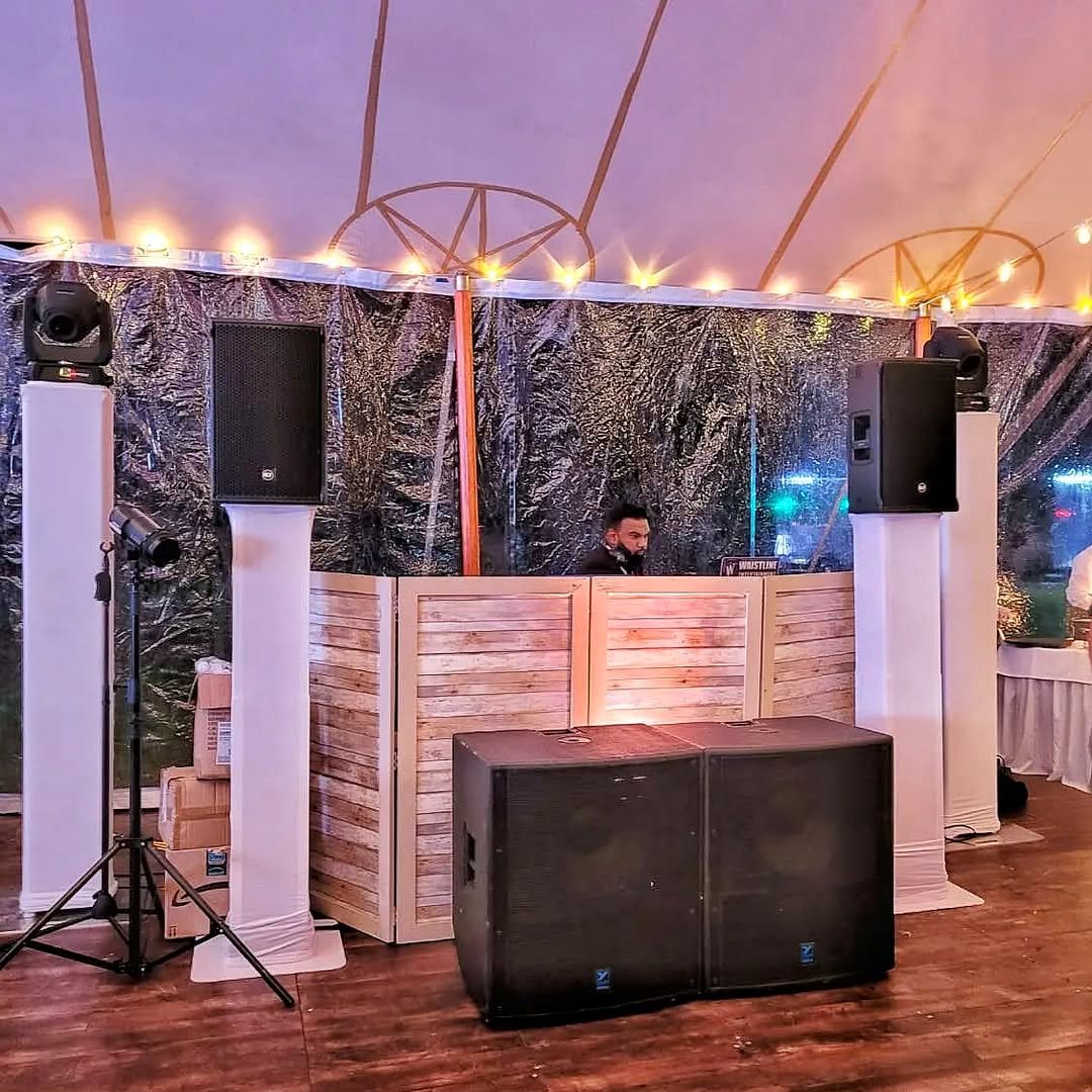 DJ booth and speaker rig set up inside an event tent