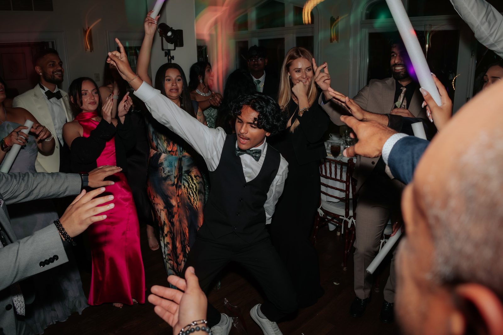 Crowd hyped up with light batons on a packed dancefloor